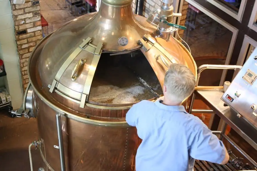 Man mixing his beer during the fermentation process