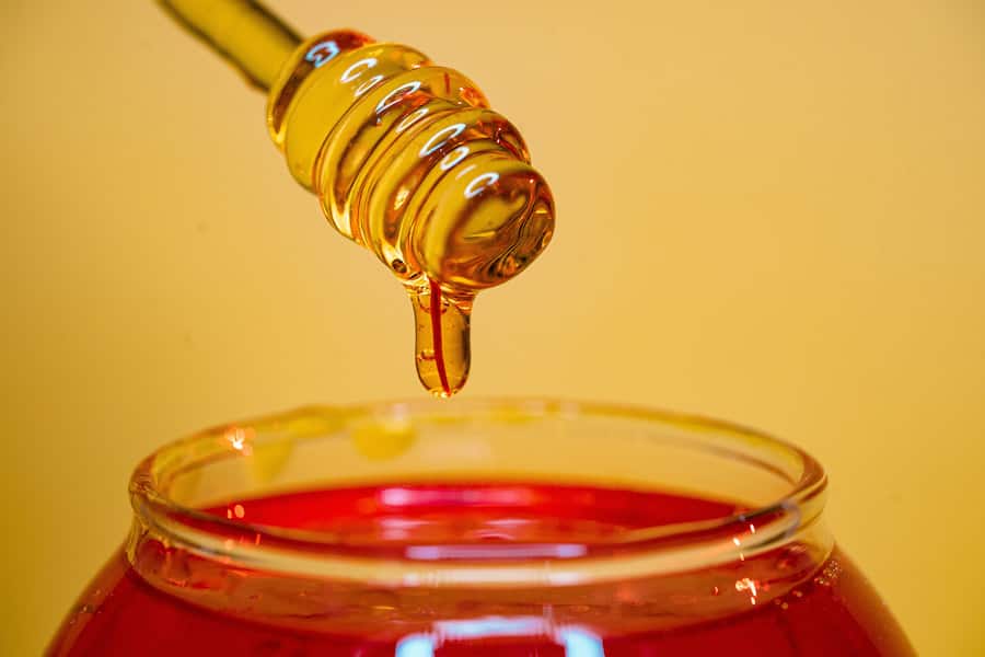Honey pouring on a clear glass