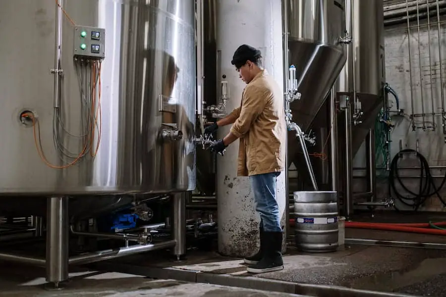 A man checking if fermentation is done