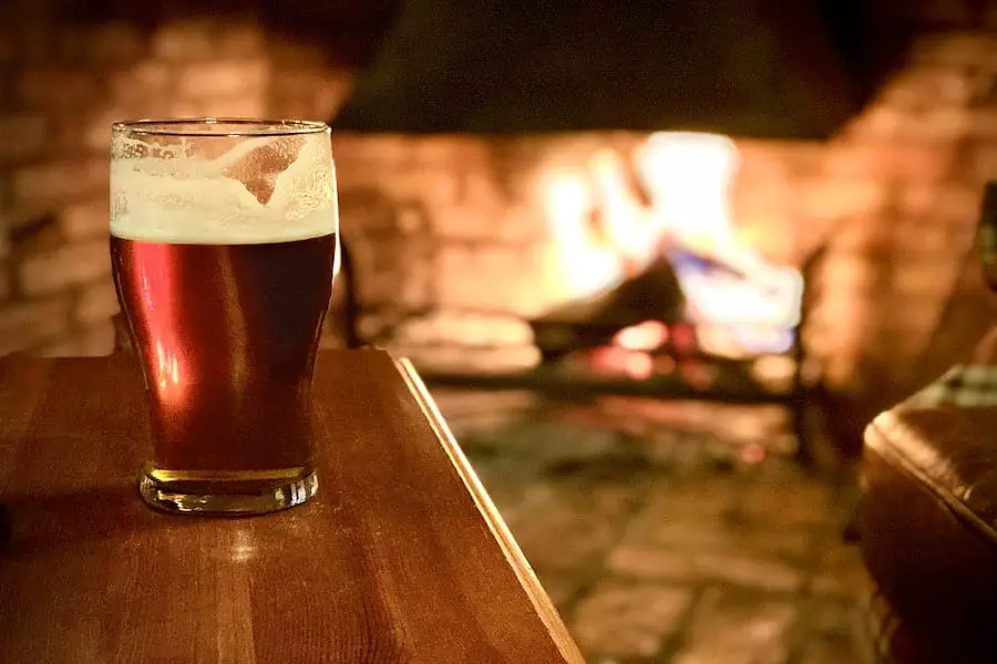 A glass of beer near a fire place