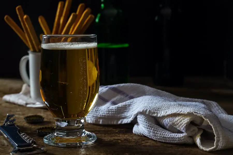 A glass of beer with bread sticks