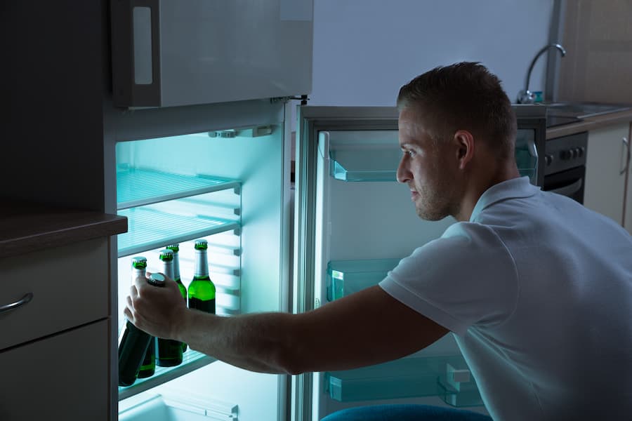 An image of a man getting beer in the fridge