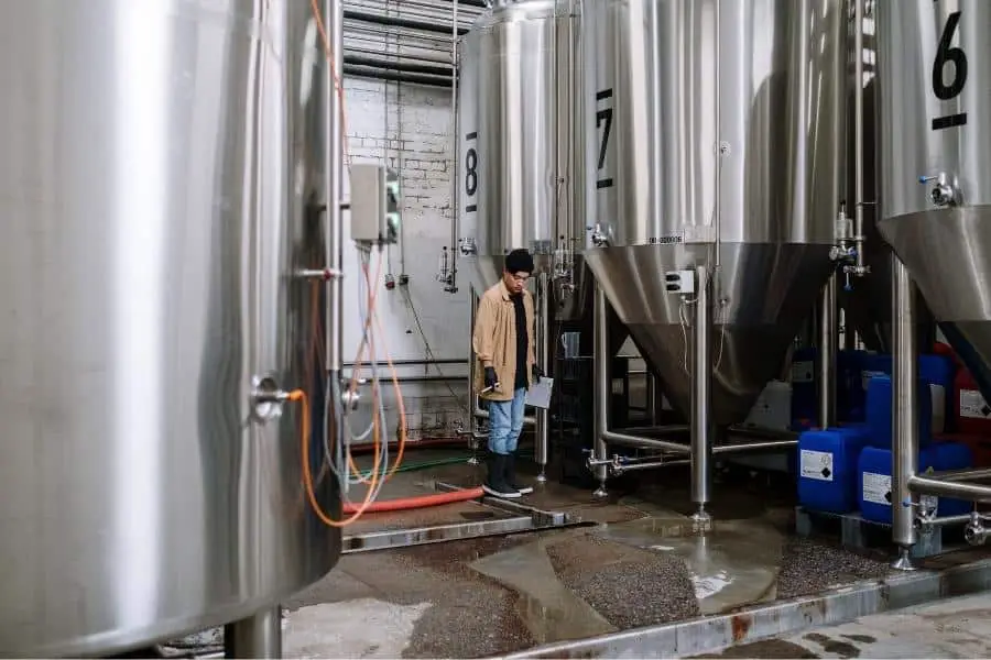 An image of a man checking the conical fermenter