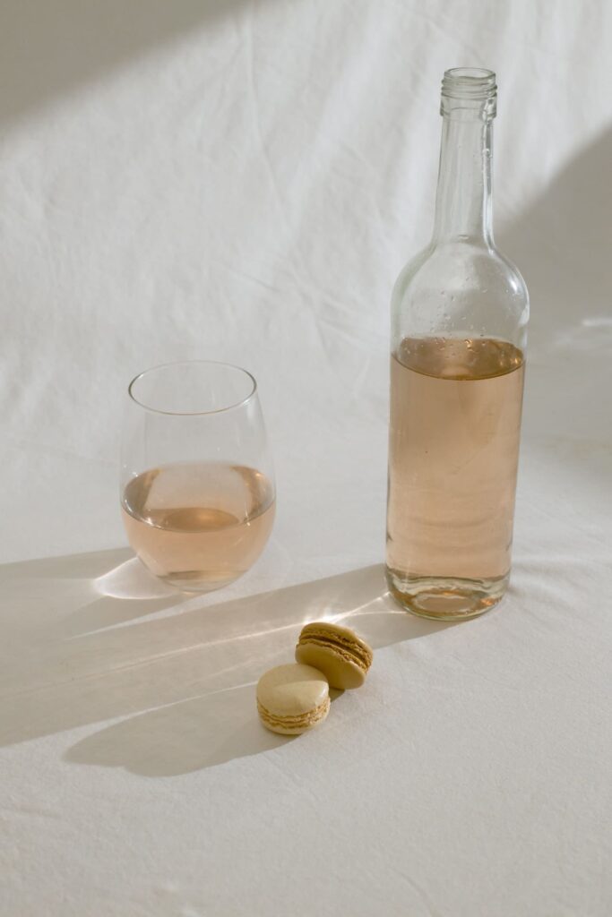 A wine bottle with glass and macaroons