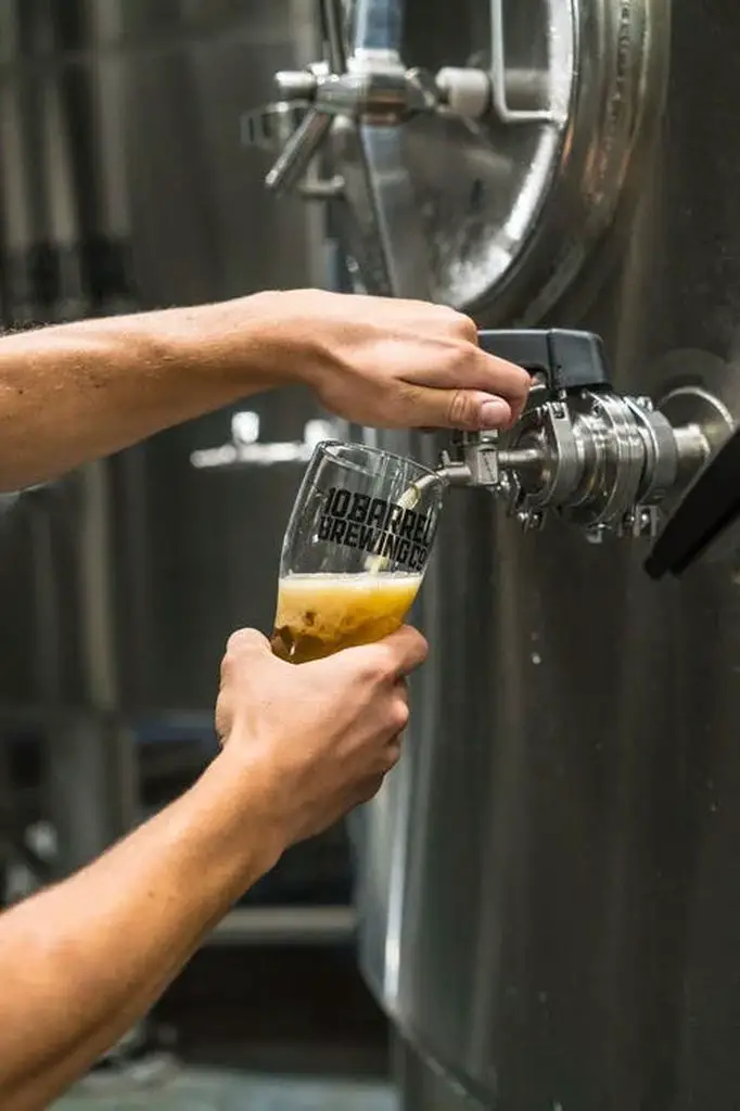 Man pouring beer out of a fermenter