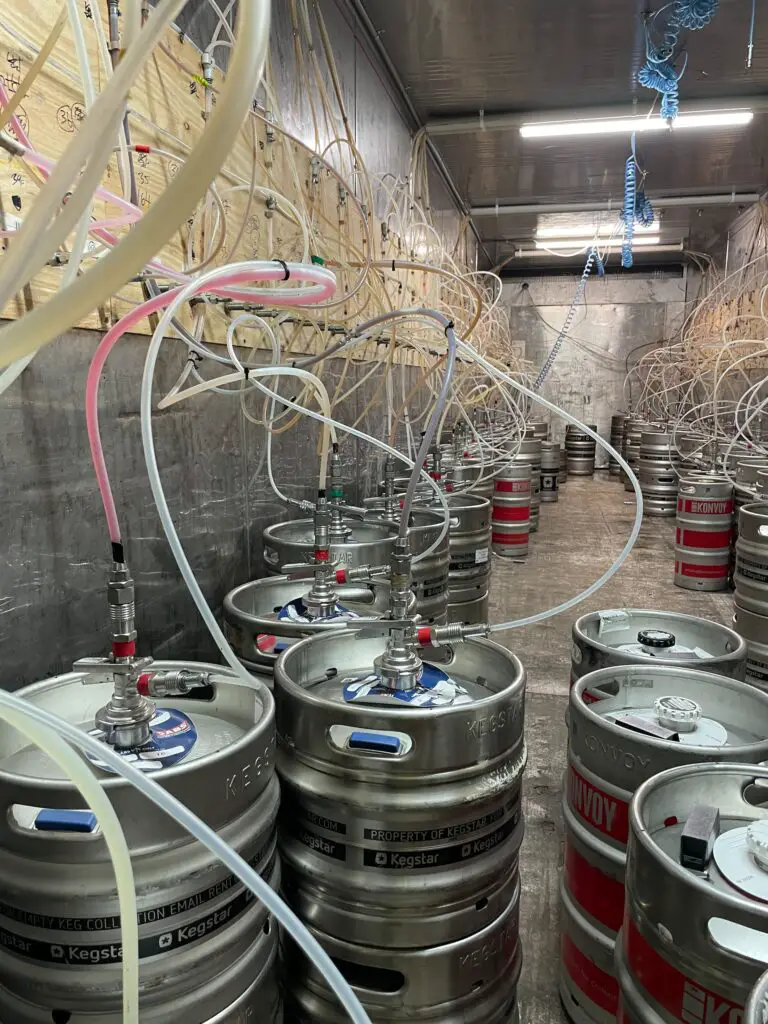 Stainless steel kegs used in storing beer are placed in a well-lit room