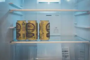 Three cans of Kirin beer classic are placed on a refrigerator