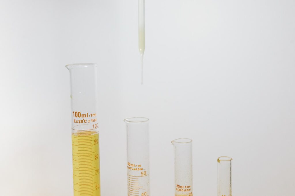 Four different sizes of a graduated cylinders and a dropper